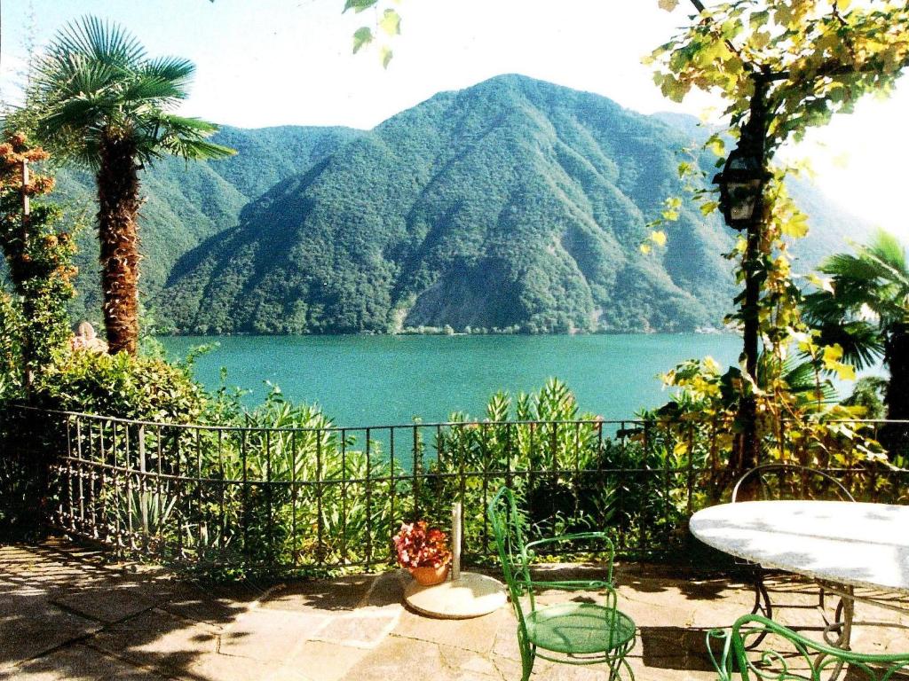 a view of a lake with a table and chairs at Barony Le Pergole Lugano Villa for 8 persons in Lugano