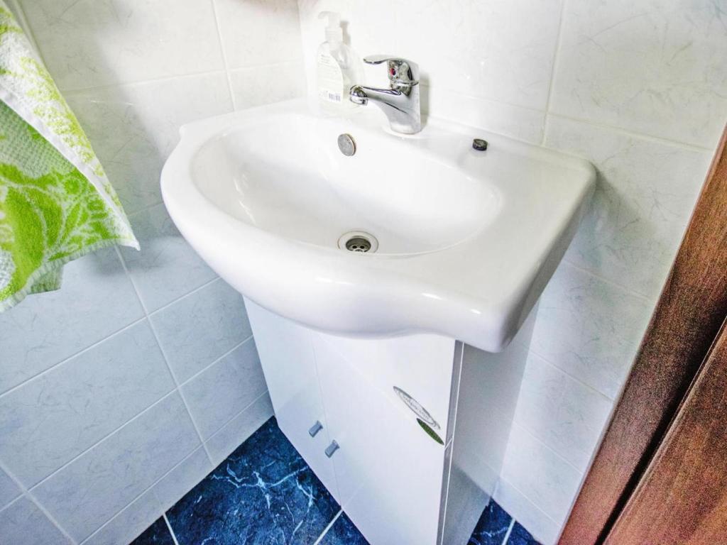 biała umywalka w łazience wyłożonej niebieskimi kafelkami w obiekcie Apartment in Starigrad Paklenica w mieście Starigrad-Paklenica