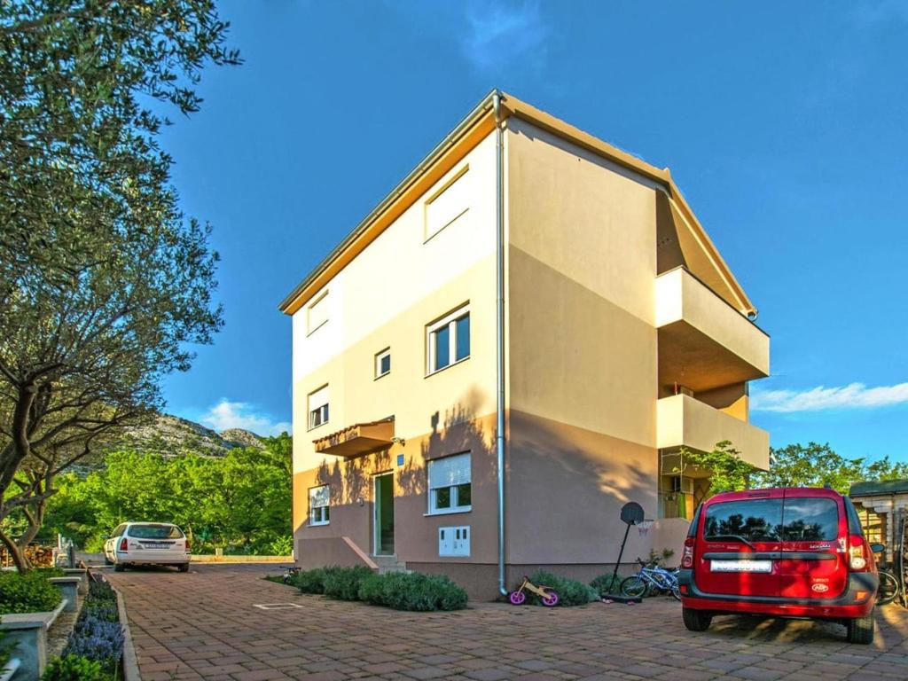 czerwony van zaparkowany przed budynkiem w obiekcie Apartment in Starigrad Paklenica w mieście Starigrad-Paklenica