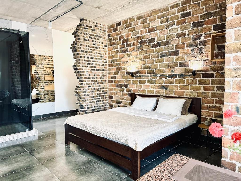 a bedroom with a bed in a brick wall at Modern apartments with a coffee machine in the city center, a view of the city in Rivne