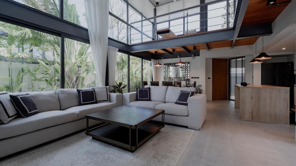 a living room with a white couch and a table at Luxury Modern Loft Villa Riverhouse in Laguna Phuket