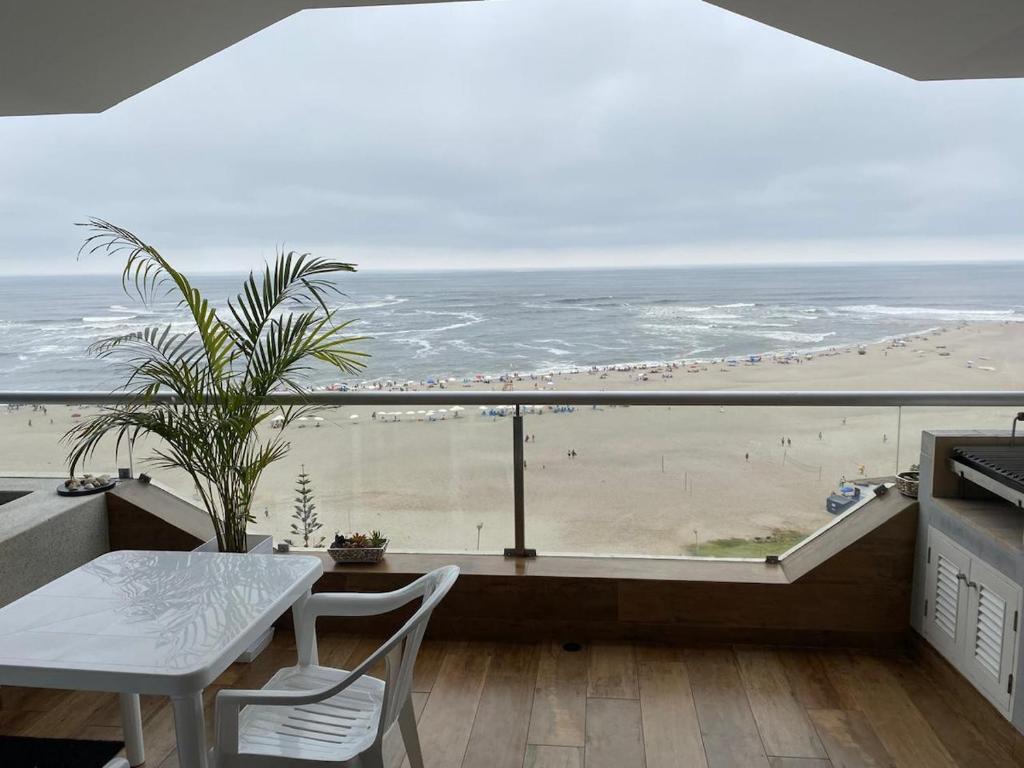een balkon met een tafel en uitzicht op het strand bij Apartment Rosi Beach & Pool Punta Hermosa in Punta Hermosa