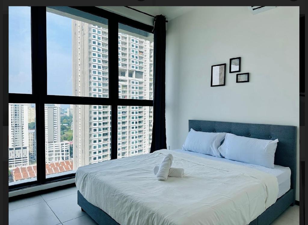une chambre avec un grand lit et de grandes fenêtres dans l'établissement Spacious 3BR Retreat Comfort & Style in the City 2-10pax, à Jelutong