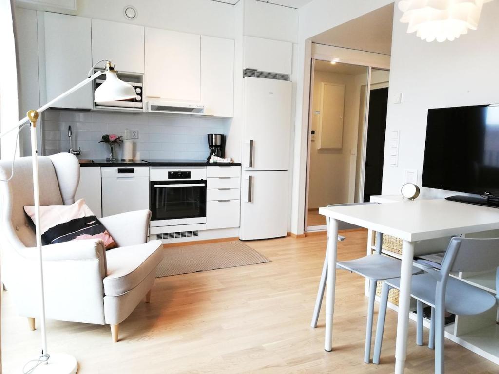 a kitchen and living room with a table and a dining room at Kotimaailma - Modern studio in Vaasa citycenter, Kirjastokatu in Vaasa