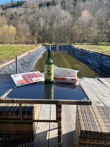 - une bouteille de vin assise au-dessus d'une table dans l'établissement gite du Breuchin trois, à La Longine