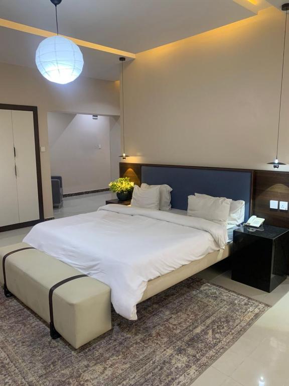 a large bedroom with a large bed with a large white bedvisor at Centurion Aparthotel in Abuja