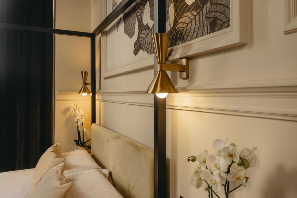a bedroom with a bed with a black headboard and lights at Roma Luxus Hotel in Rome