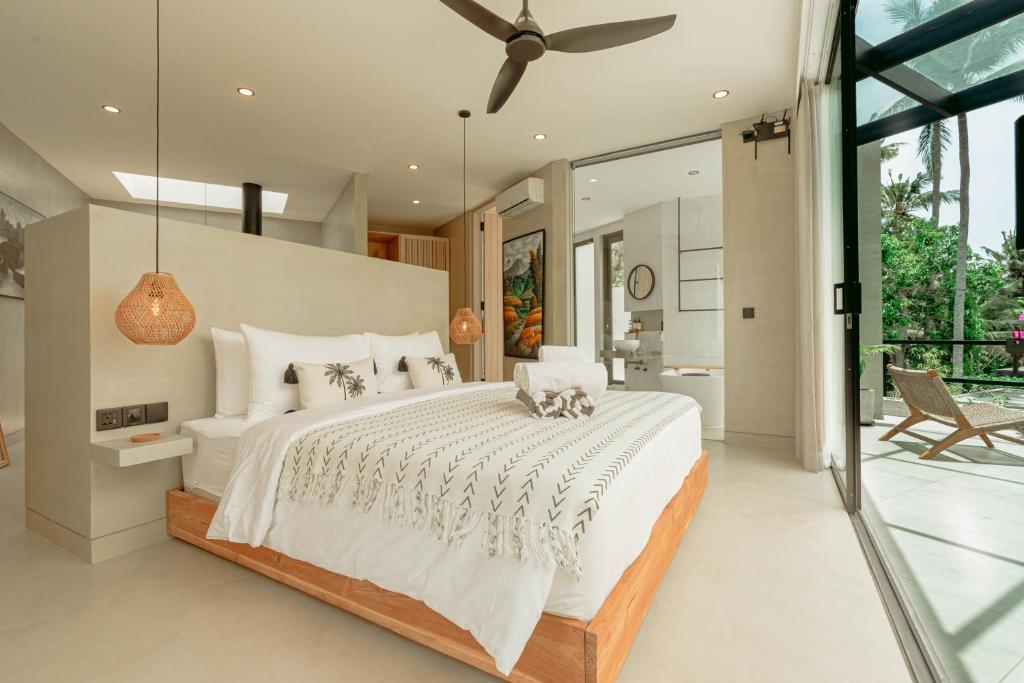 Un dormitorio con una cama grande y una puerta corrediza de vidrio. en Makai Kedungu, en Tanah Lot