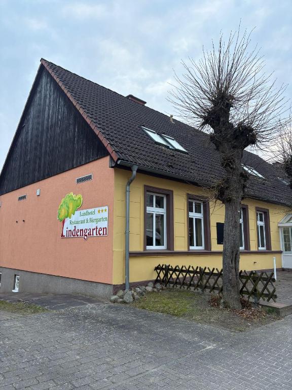 a building with a sign on the side of it at Landhotel Lindengarten in Kleinzerlang