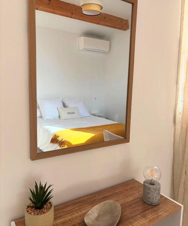 un miroir sur un mur avec un lit dans une chambre dans l'établissement Appartement 2 personnes bord de mer, à Sagone