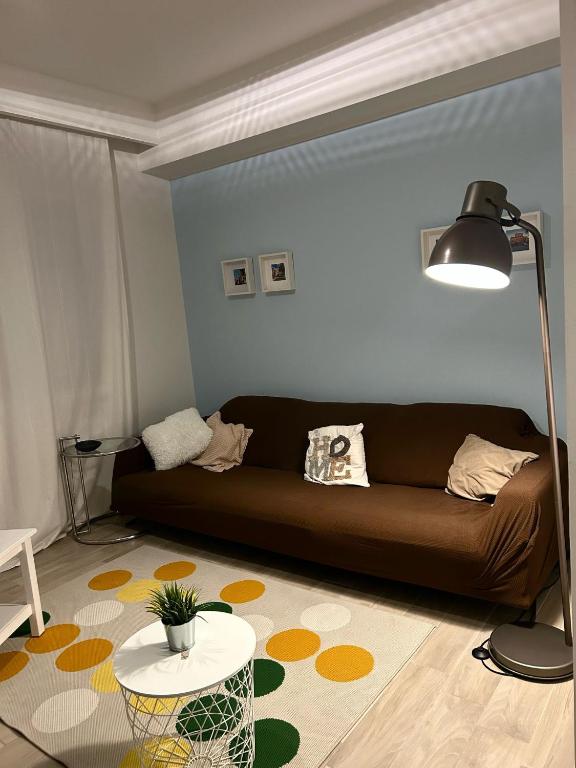 salon z brązową kanapą i stołem w obiekcie Casa di Ily w Rawennie