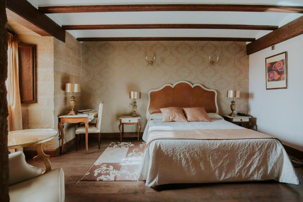 a bedroom with a large bed and a table at Hospedería Palacio de Casafuerte in Zarratón