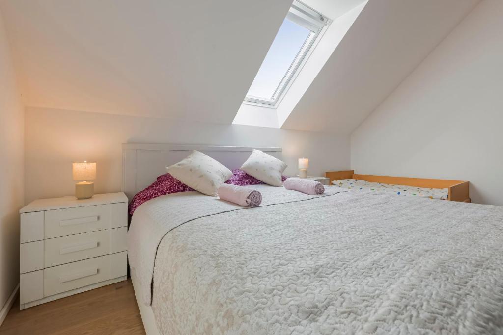 a bedroom with a large white bed with two lamps at Guest House KRISTI in Tuchoměřice