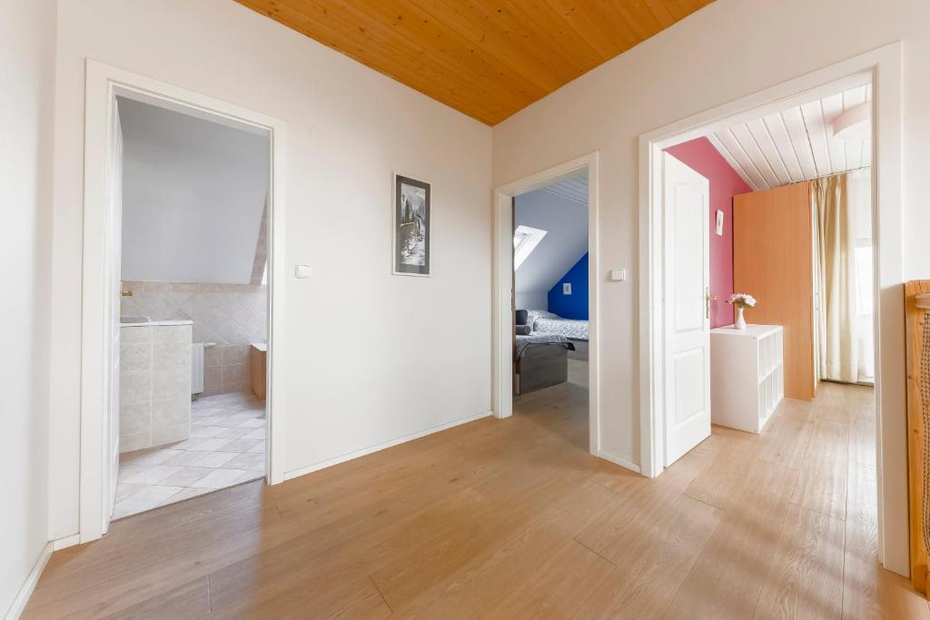 a large room with white walls and a wooden ceiling at Guest House KRISTI in Tuchoměřice
