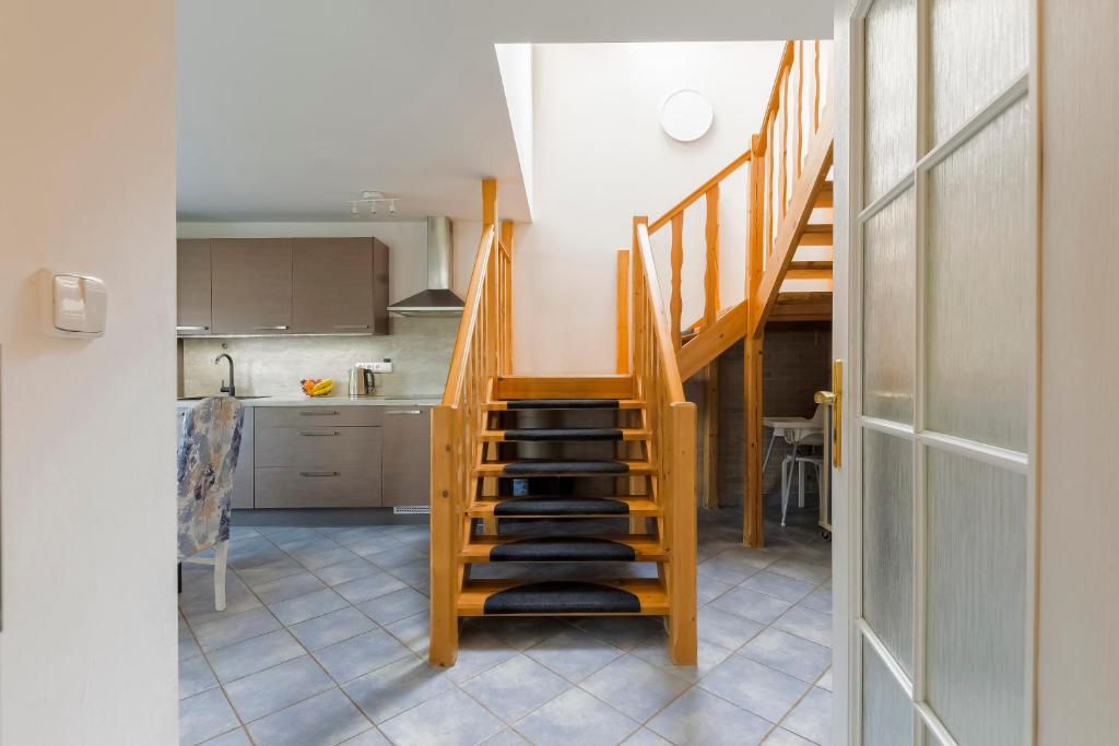 a kitchen with a staircase in a room with a table at Guest House KRISTI in Tuchoměřice