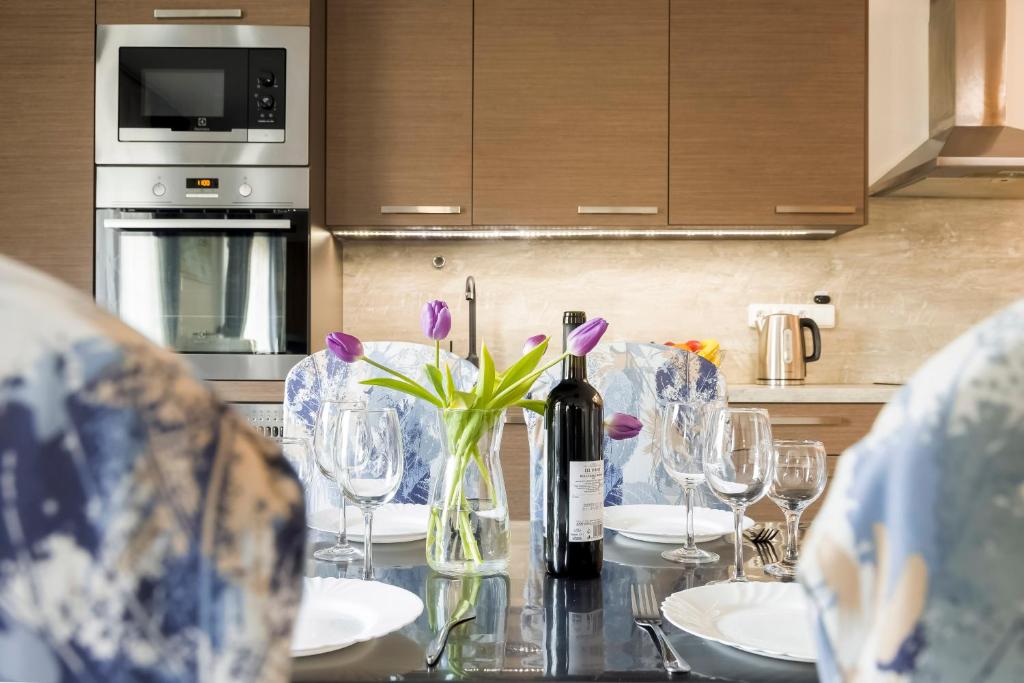 a table with a bottle of wine and flowers on it at Guest House KRISTI in Tuchoměřice