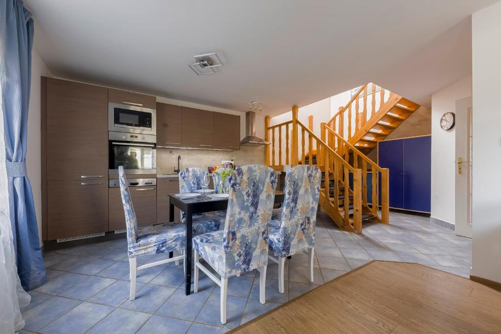a kitchen and dining room with a table and chairs at Guest House KRISTI in Tuchoměřice