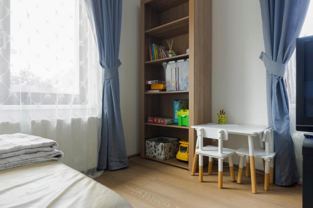 a bedroom with a table and chairs and a book shelf at Guest House KRISTI in Tuchoměřice