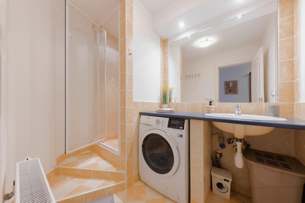 a bathroom with a washing machine and a sink at Guest House KRISTI in Tuchoměřice
