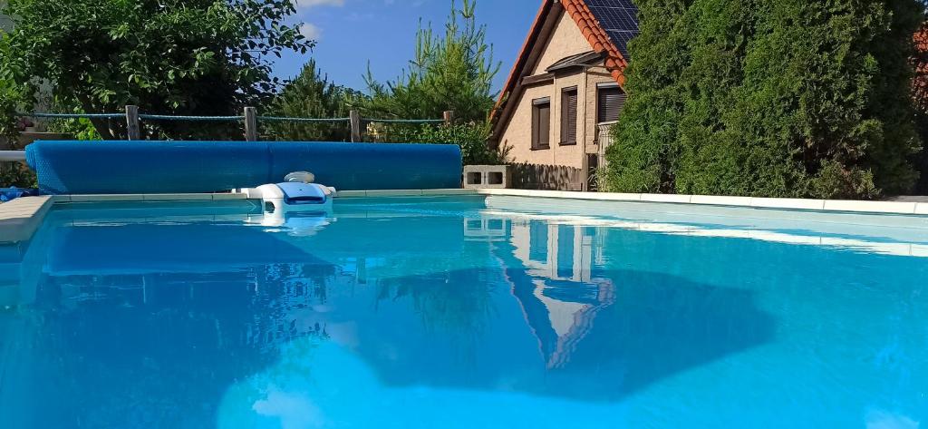 a swimming pool with blue water and a blue couch at Guest House KRISTI in Tuchoměřice