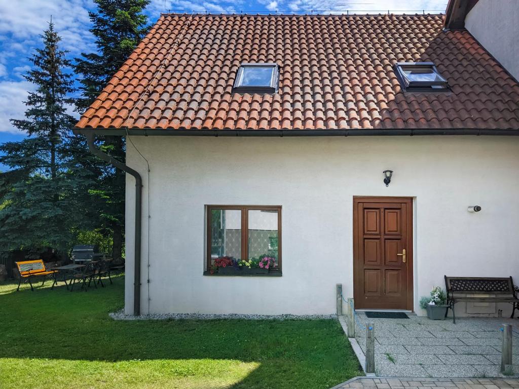 a white house with a door and a window at Guest House KRISTI in Tuchoměřice