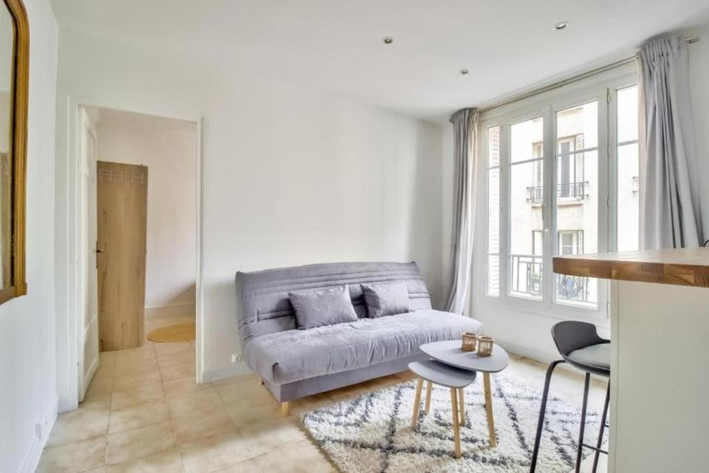 un salon avec un canapé et une table dans l'établissement Nice Flat Jules Joffrin station and Clignancourt, à Paris