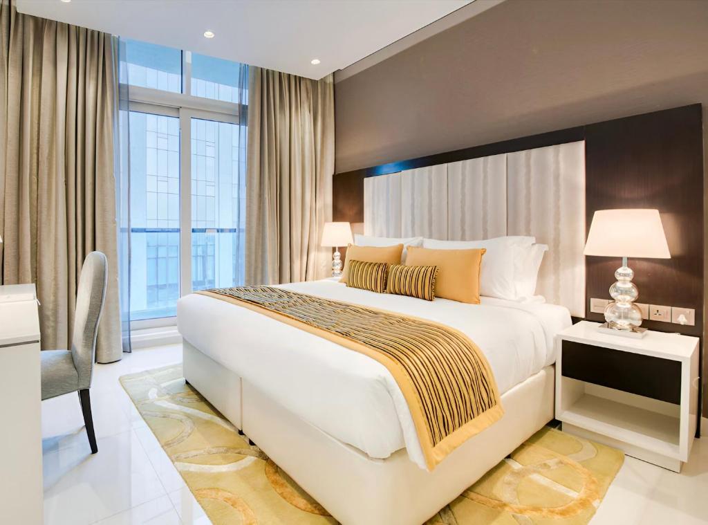 a hotel room with a large bed and a desk at Nice 2 Bedroom Apartment! 5 Minute walk to Dubai Mall! Burj Khalifa View! in Dubai