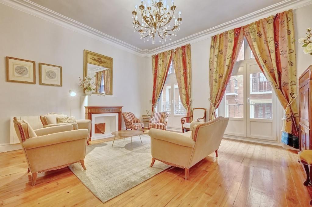 a living room with chairs and a chandelier at Heart of Pamplona Apartments III by clabao in Pamplona
