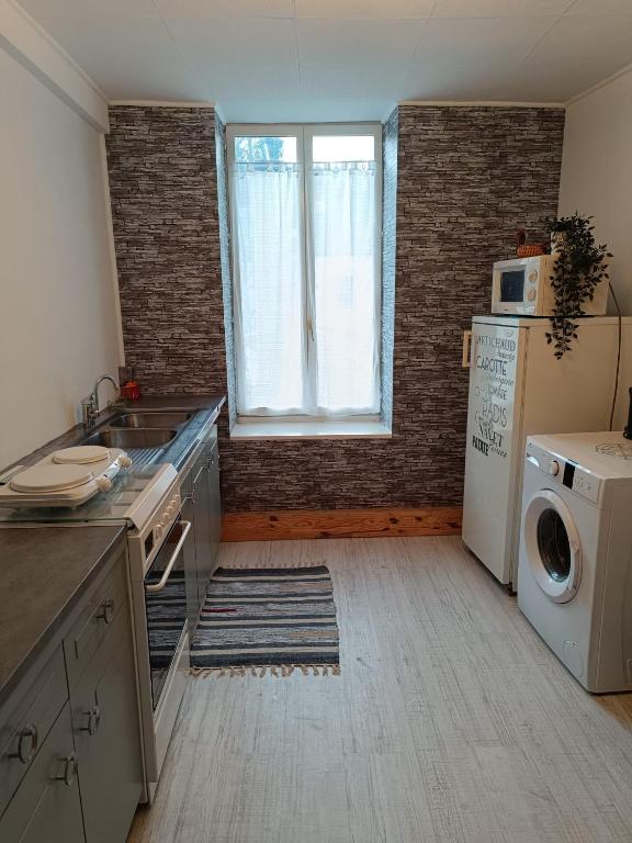 une cuisine avec un évier et une machine à laver dans l'établissement Appartement au centre de Bourbon, à Bourbon-lʼArchambault