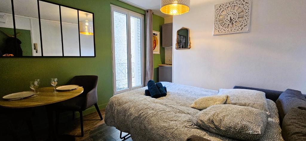 a living room with a table and a couch at La cachette de la Reine in Fontainebleau