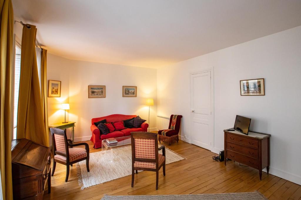 - un salon avec un canapé et des fauteuils rouges dans l'établissement Parisian Home 398 1 chambre Dupleix - Motte Piquet - Grenelle, à Paris