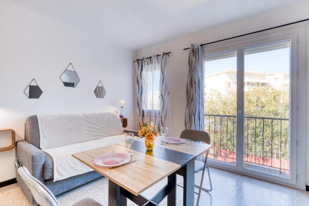 d'un salon avec une table et un lit ainsi que d'un balcon. dans l'établissement L’amar-et-lys, à Palavas-les-Flots