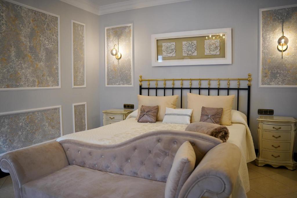 a bedroom with a large bed and a couch at Hotel Boutique Casa Veracruz in Estepona