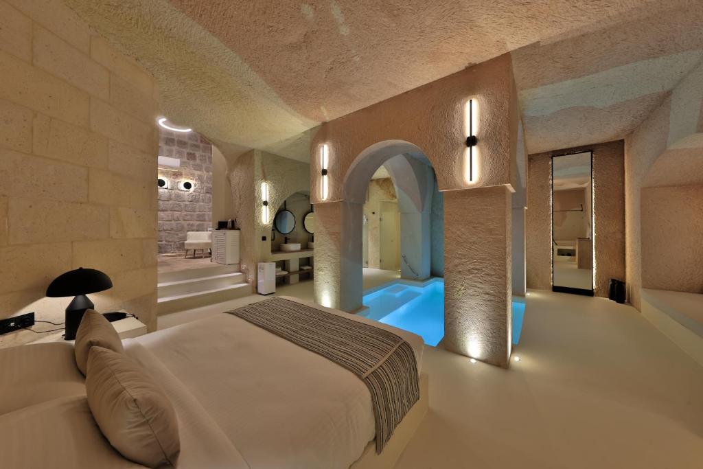 a bedroom with a large bed and a bath tub at Simurg Cave House in Ürgüp