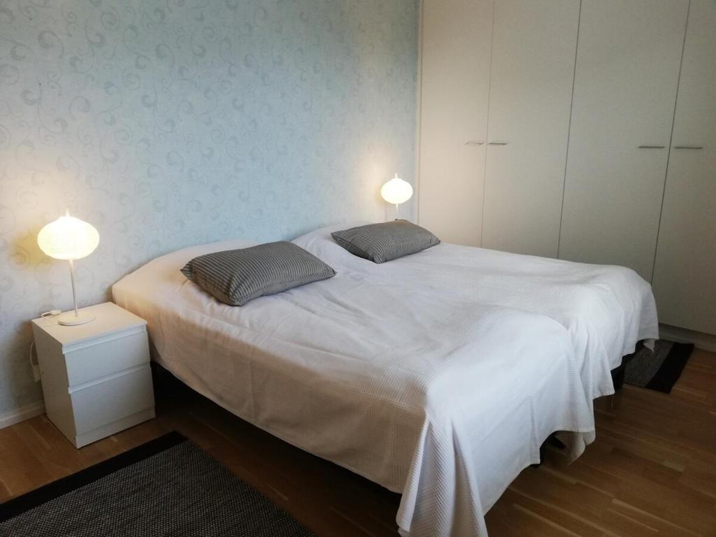 a bedroom with a large white bed with two pillows at Kotimaailma Two bedroom apartment with private sauna in Vaasa