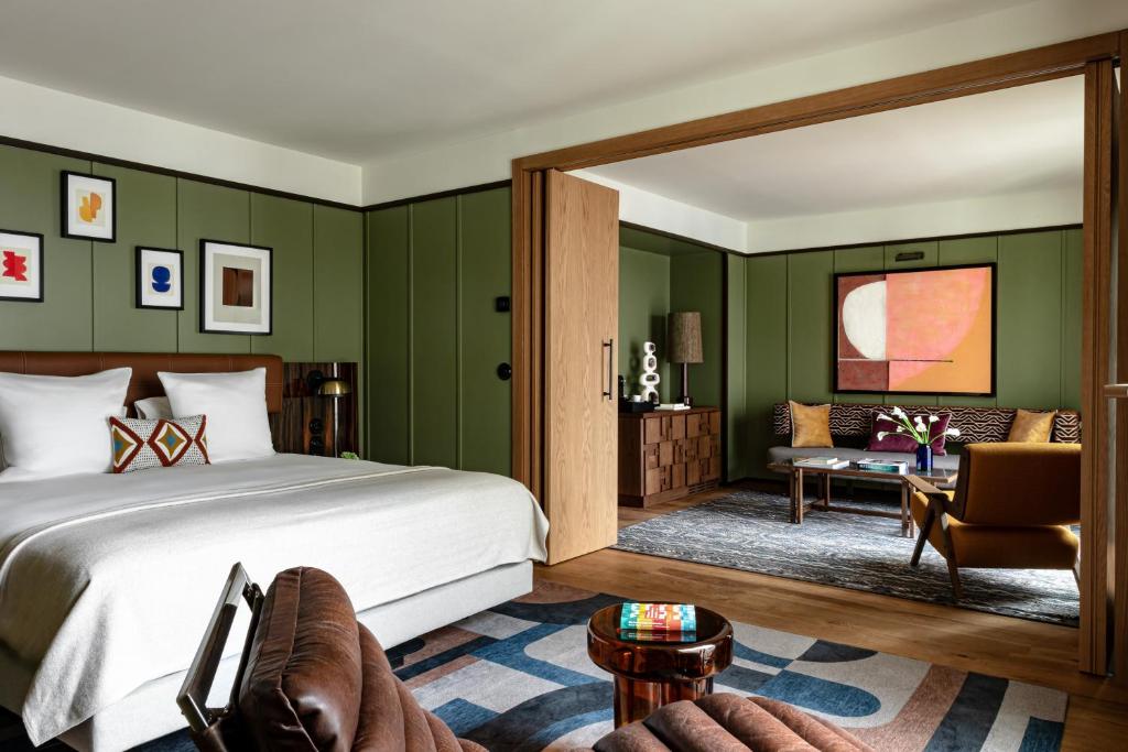 - une chambre avec des murs verts, un lit et un canap&eacute; dans l'&eacute;tablissement Norman Paris H&ocirc;tel & Spa, &agrave; Paris