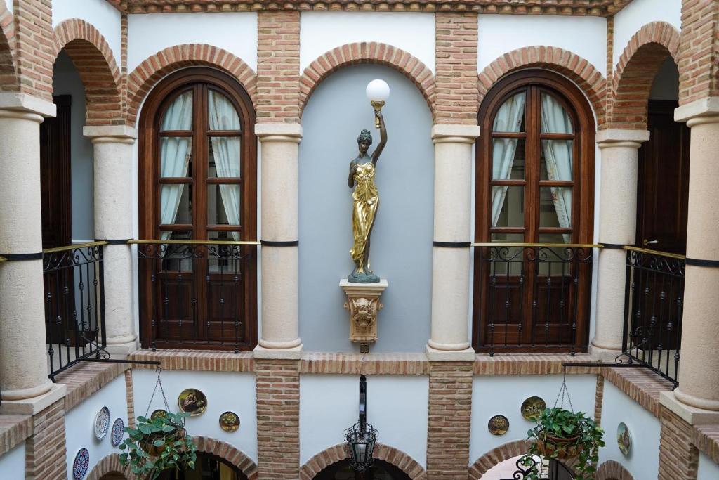 a statue on the side of a building with windows at Hotel Boutique Casa Veracruz in Estepona
