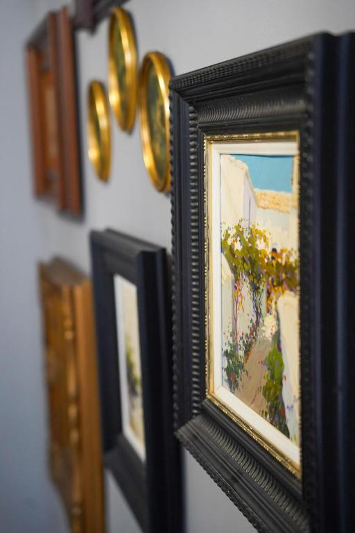 a row of framed paintings on a wall at Hotel Boutique Casa Veracruz in Estepona