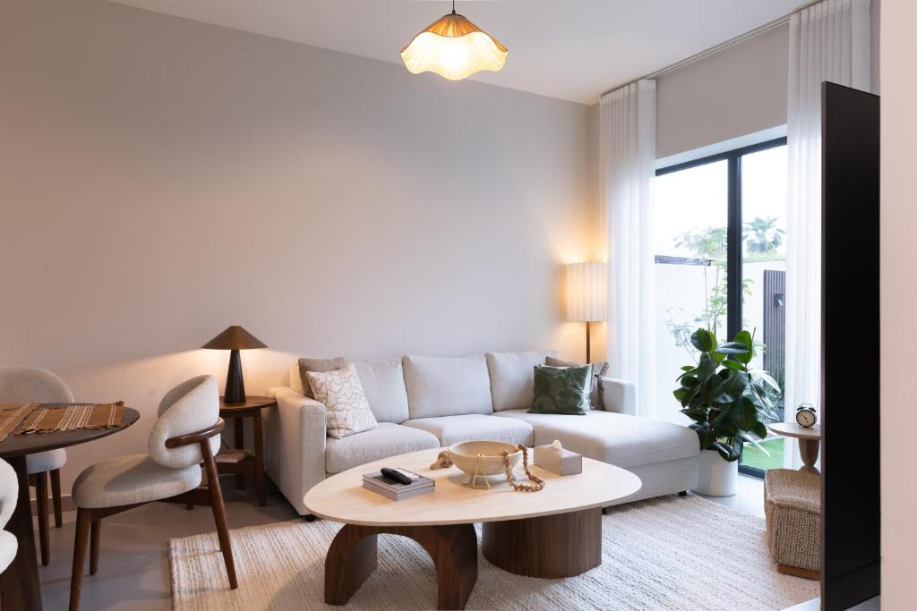 a living room with a white couch and a table at Your Cozy Yas Island Escape in Abu Dhabi