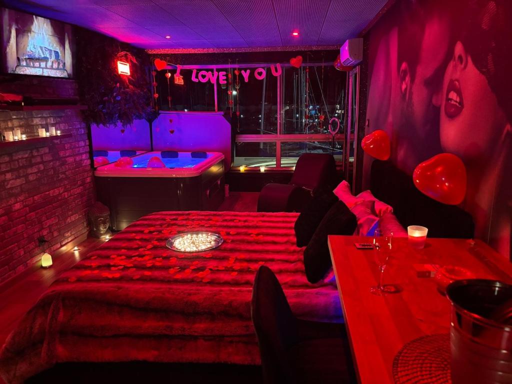 une chambre avec un lit et une table avec des lumières rouges dans l'établissement Evasion en couple cap d'agde, au Cap d'Agde