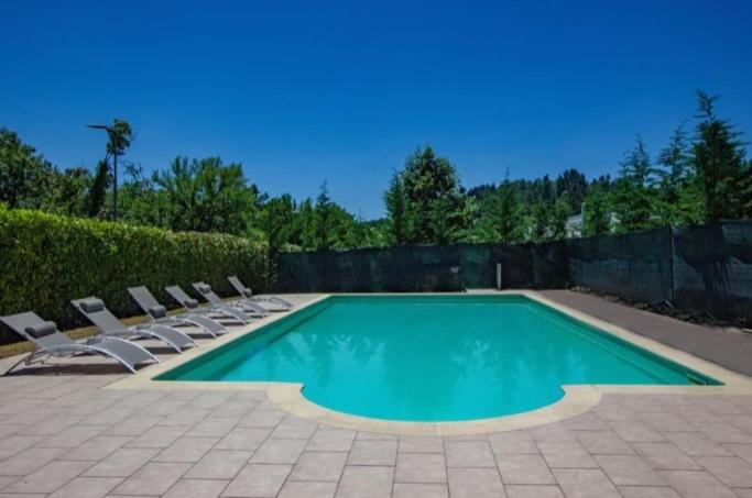 a swimming pool with lounge chairs and a fence at - Luxury Villa Lunigiana Private Swimming Pool- in Bagnone
