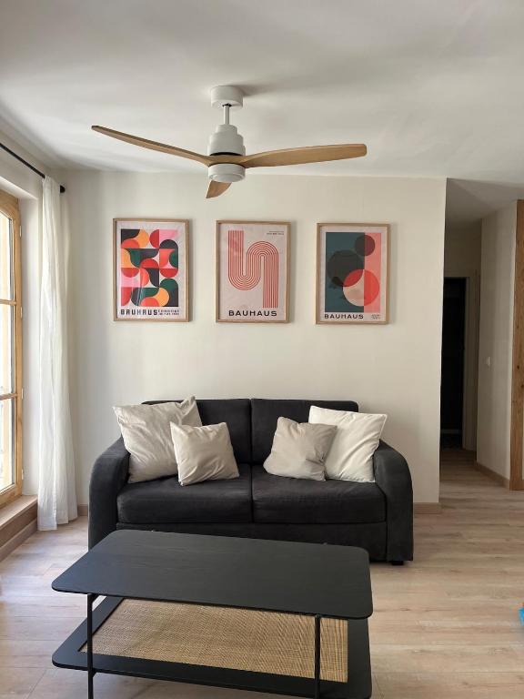 un salon avec un canapé et un ventilateur de plafond dans l'établissement Cozy Appartment Champollion 1, à Figeac