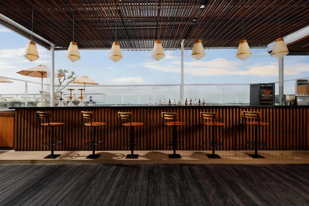 a bar with stools in front of a counter at Aston Canggu Beach Resort in Canggu