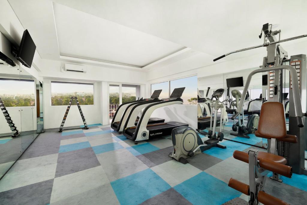 a gym with tread machines and a bed in a room at Aston Canggu Beach Resort in Canggu