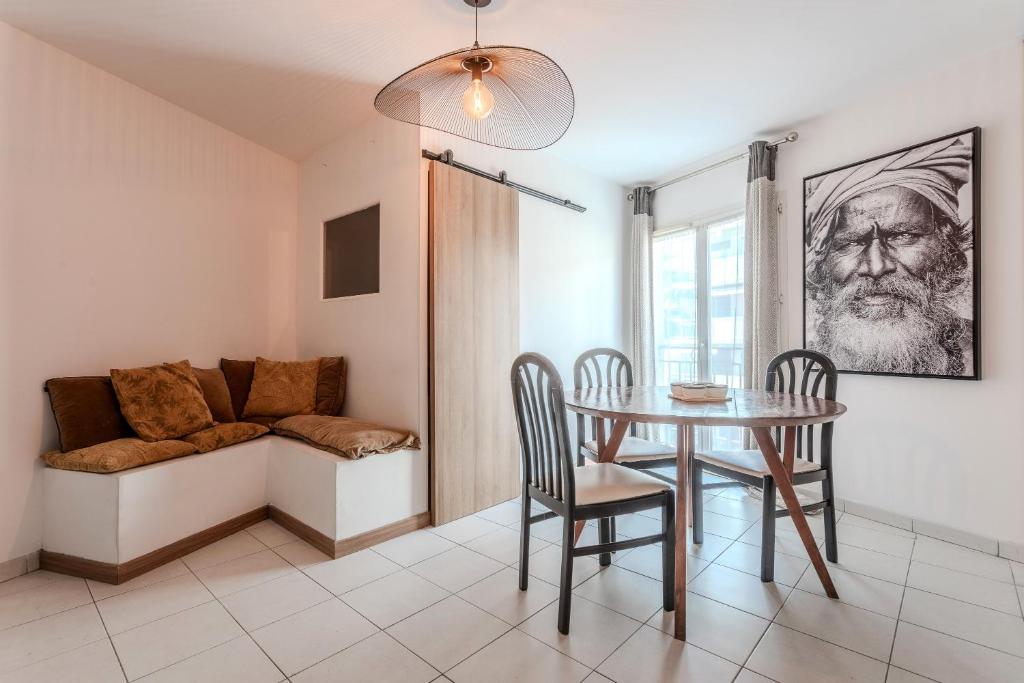 une salle à manger avec une table, des chaises et un canapé dans l'établissement L'Ensoleillé à 100m de la plage, à Sainte-Maxime