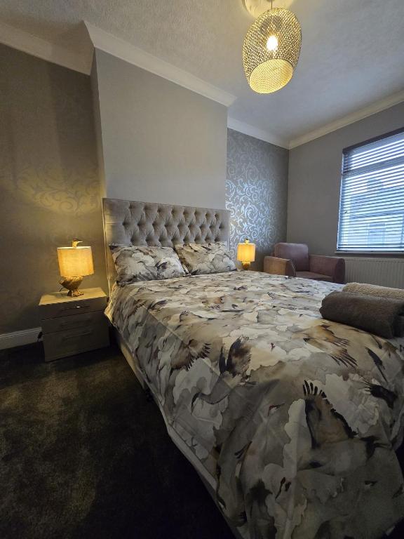 a bedroom with a large bed and two lamps at Aldam House in Darlington