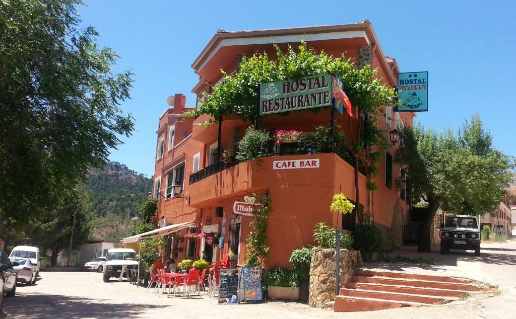 un edificio naranja con plantas a su lado en Hostal Almenara, en Paterna del Madera