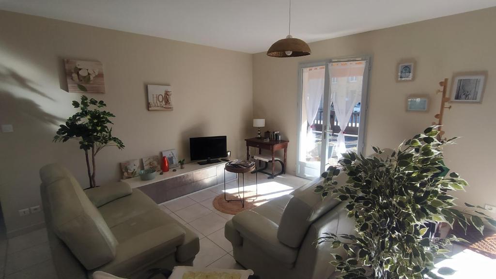 un salon avec un canapé, des chaises et une télévision dans l'établissement L'Olivier Maison de village avec jardin au calme pour 6 pers, à Saint-Cyprien