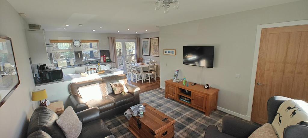 a living room with a couch and a table at Ben Lomond Cottage in Arrochar