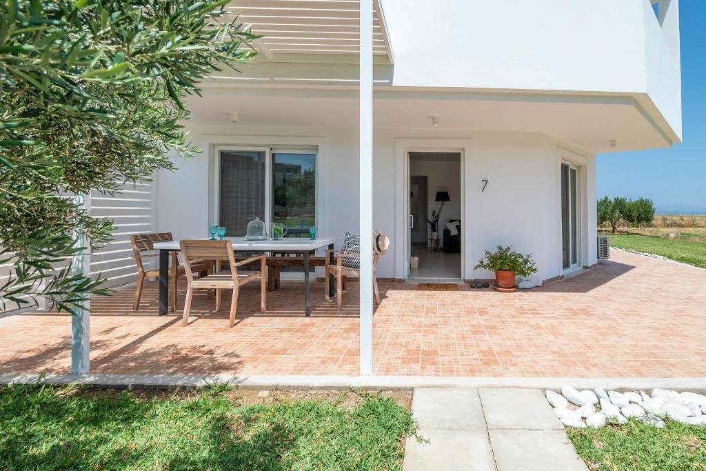 a patio with a table and chairs on it at Einalia Holiday Homes by the Beach in Kardamaina